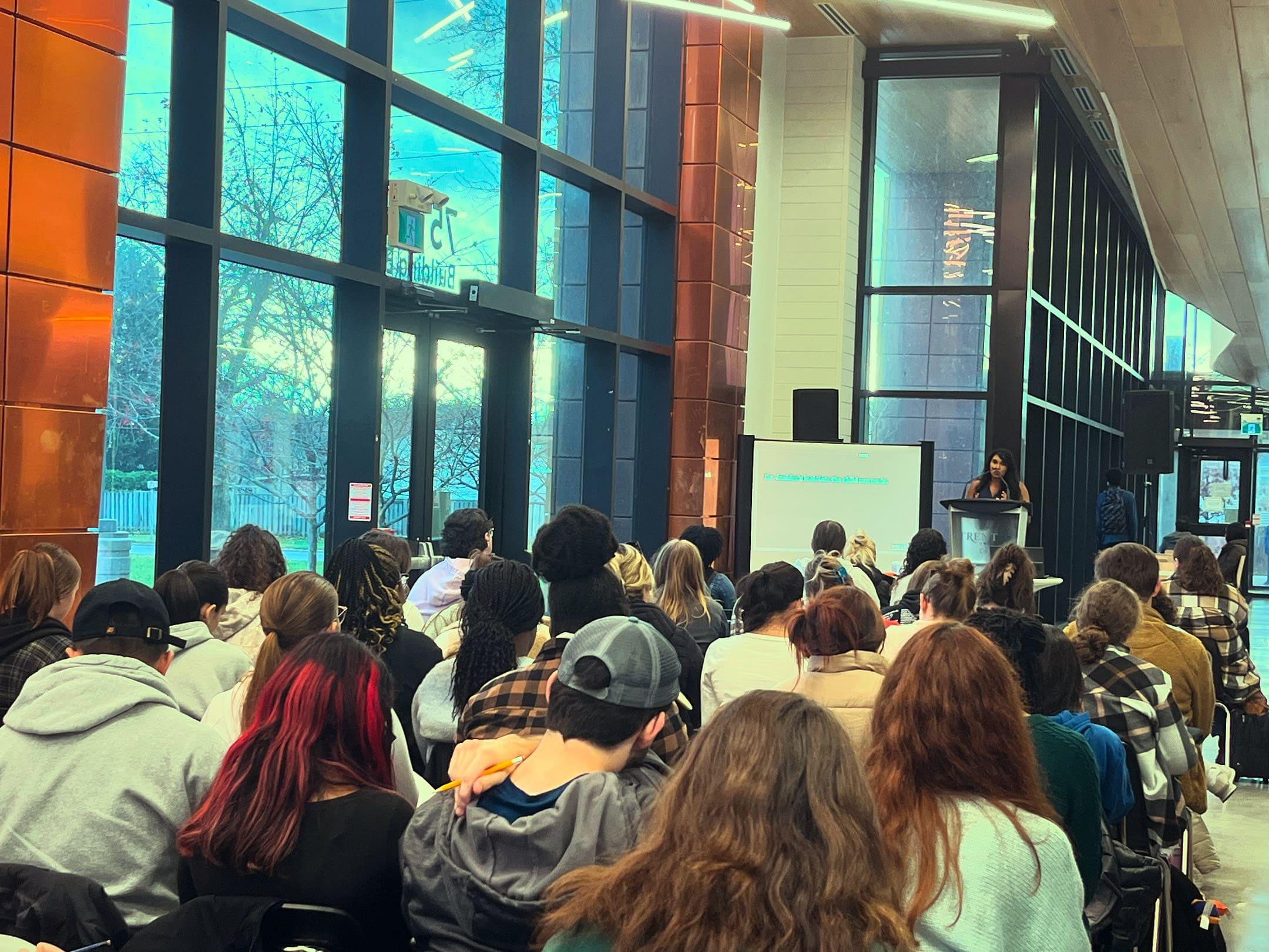 OneChild speaker addressing a packed student audience at Trent University