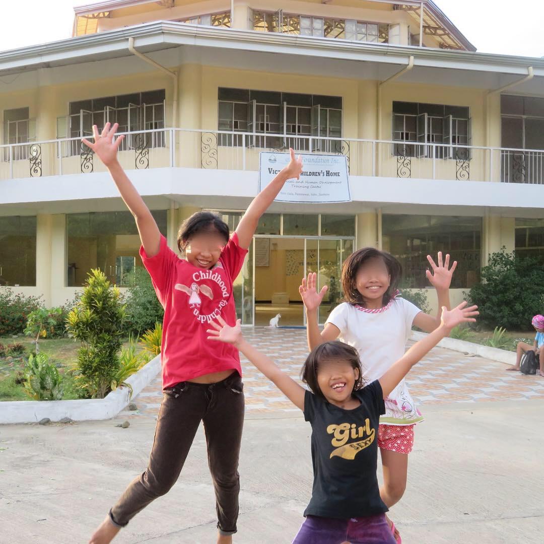 Children celebrating outside a children's home supported by OneChild