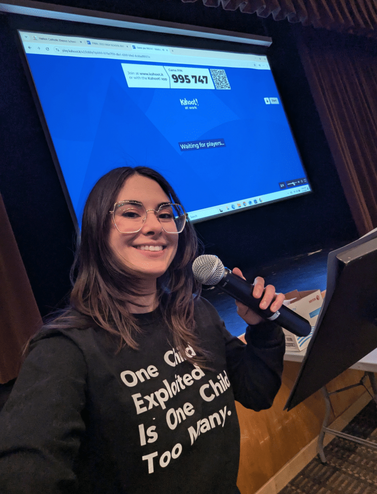OneChild presenter with a microphone leading a school session